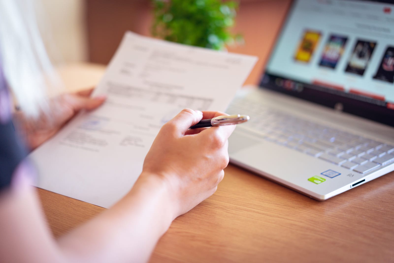 Przedsiębiorca analizuje dokumenty przy laptopie